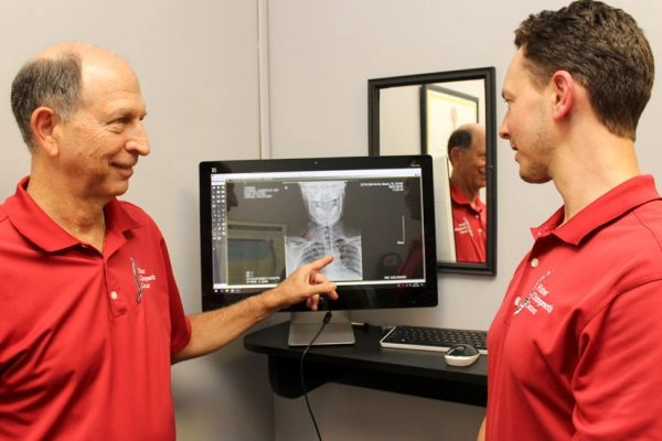 Men reviewing spinal x-ray on computer monitor
